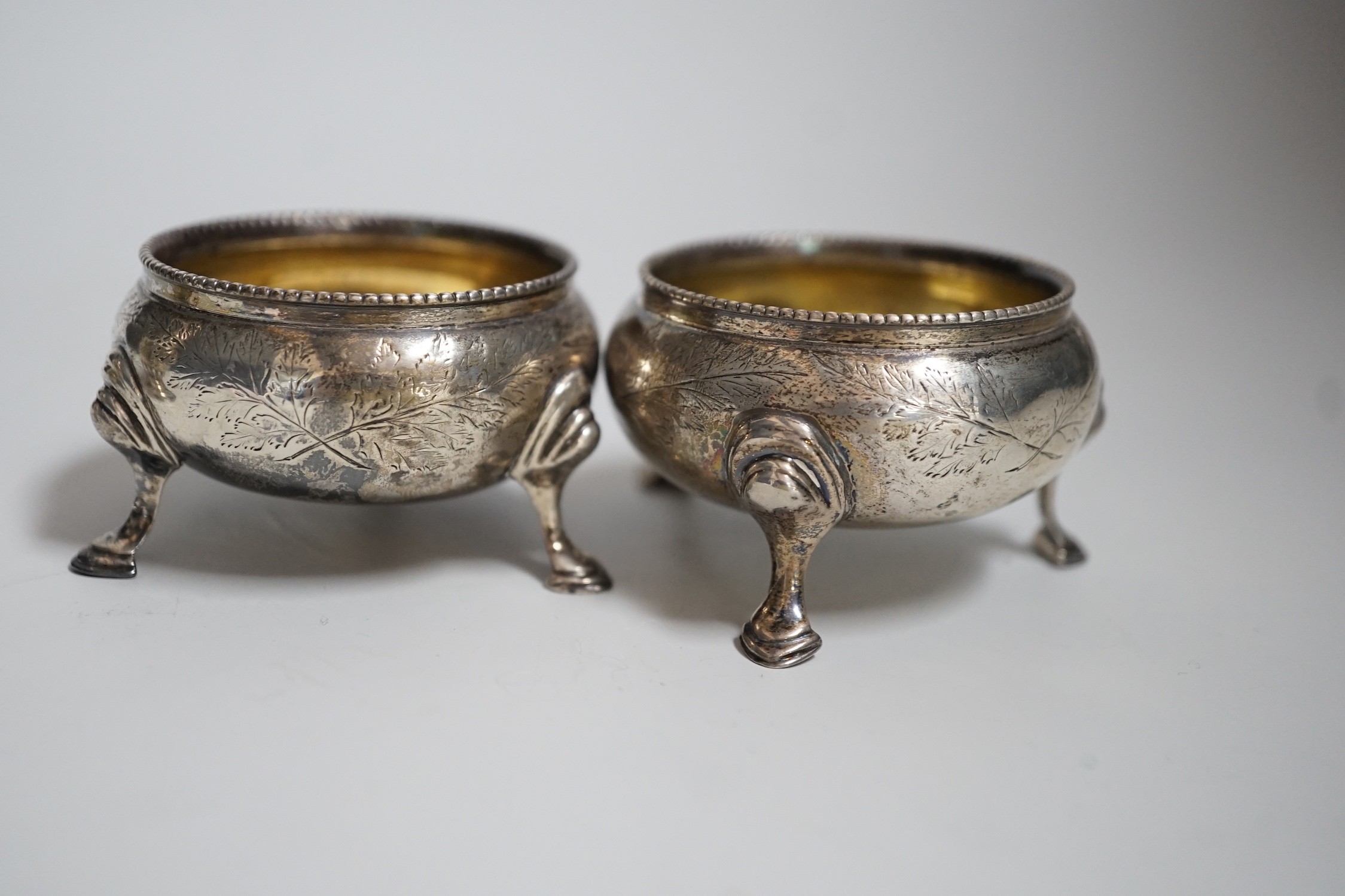 A pair of Victorian silver bun salts, London, 1868, diameter 5cm and a pair of Victorian silver peppers.